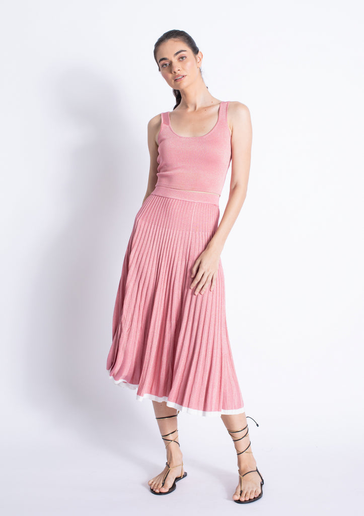 A female model wearing a pink sleeveless pleated knee-length dress with a square neckline. Karina Grimaldi Primrose Knit Set