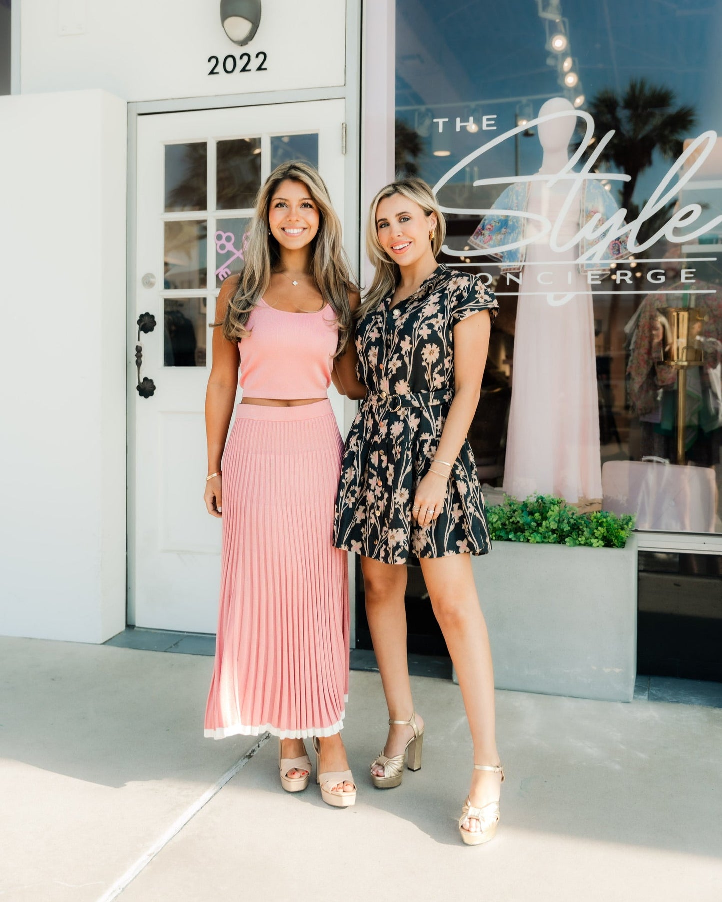 Two women standing outside a store with a 'The Style Concierge' sign.